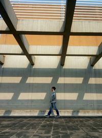 Full length rear view of man walking in corridor