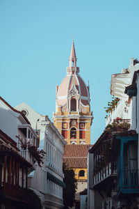 Low angle view of buildings against clear blue sky
