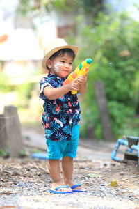 Full length of boy playing wit water gun