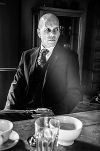 Businessman looking away while sitting by table