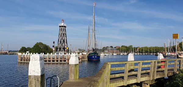 Sailboats in harbor against sky