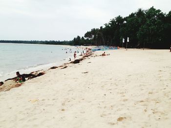 People at beach against sky