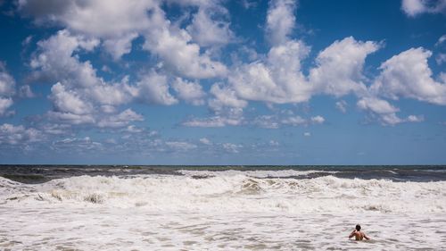 Man in sea against sky