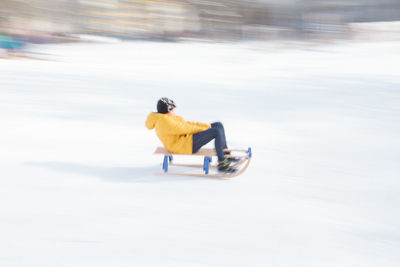 Side view of person riding motorcycle on snow