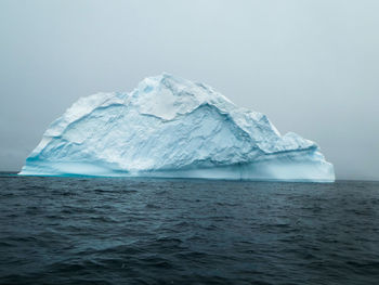 Large blue iceberg on dark water in antarctica