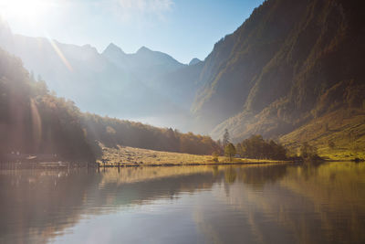 Scenic view of lake by mountains against sky