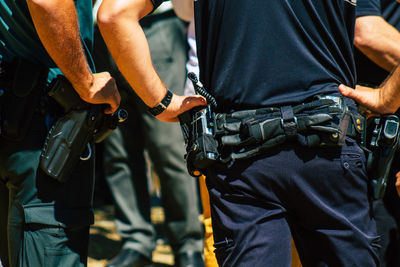 Midsection of man holding camera while standing outdoors