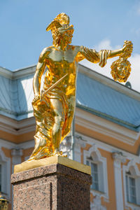 Low angle view of angel sculpture against building