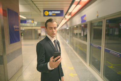 Man standing on train at railroad station platform