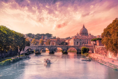 Arch bridge over river during sunset