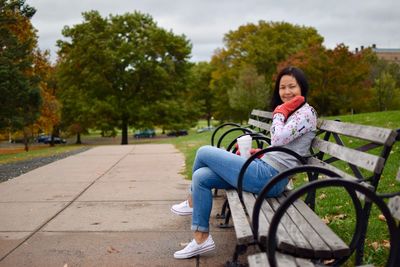 Woman sitting on bench in park