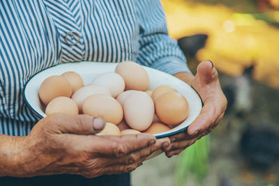 Midsection of senior woman holding eggs in bowl