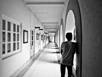 Rear view of man standing in corridor