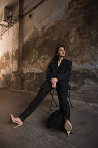 Portrait of young woman against wall