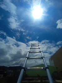 Low angle view of ladder on building against sky