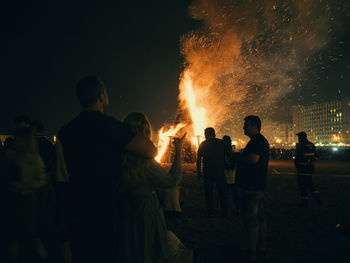 Rear view of people watching fire crackers at night