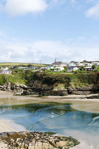 Scenic view of river by buildings against sky