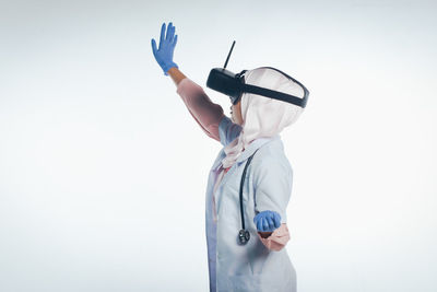 Side view of man holding camera against white background