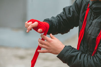 Midsection of man holding red while standing outdoors