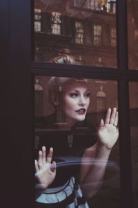 Portrait of woman seen through glass window