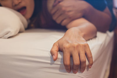 Cropped image of couple doing sex on bed at home