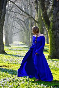 Female model posing in blue evening gown at park