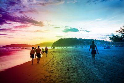 People at beach during sunset