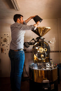 Barista preparing coffee in machinery at cafe