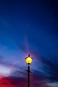 Low angle view of illuminated street light against sky at sunset