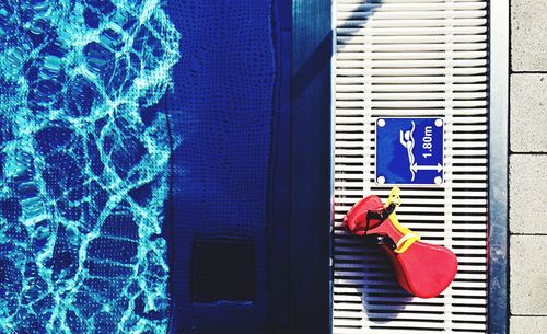 Directly above shot of equipment by information sign on poolside