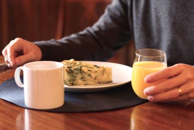 Midsection of man eating breakfast at table