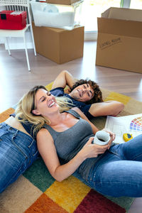 High angle view of couple lying on rug at home