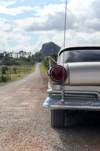 View of country road against cloudy sky