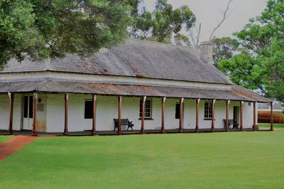 House on field by lawn against sky