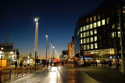 People on illuminated street at night