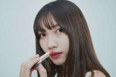 Close-up portrait of a beautiful young woman over white background