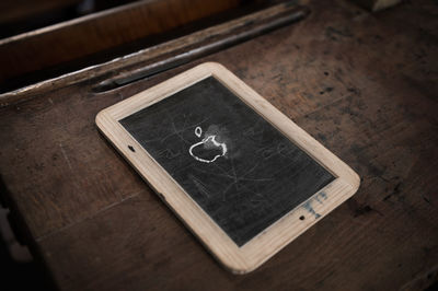 High angle view of blackboard on wooden table