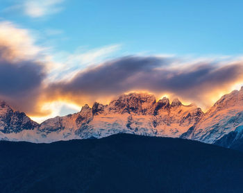 Scenic view of snowcapped mountains against sky during sunset