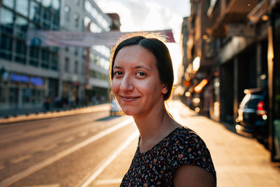 Portrait of mid adult woman standing on sidewalk in city