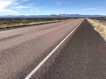 Empty road on field against sky