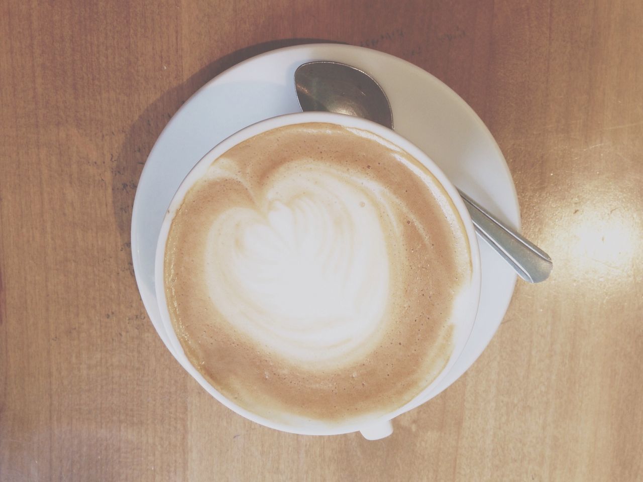 drink, coffee cup, food and drink, indoors, refreshment, saucer, coffee - drink, table, frothy drink, cappuccino, freshness, froth art, still life, coffee, high angle view, directly above, spoon, cup, close-up, latte