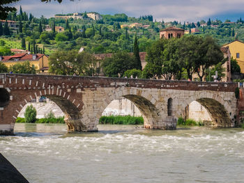 Bridge over river in city against sky