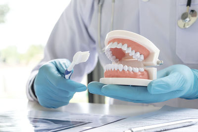 Close-up of dentist working at desk in medical clinic