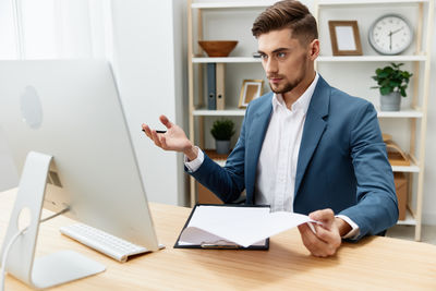 Portrait of businessman using laptop at office