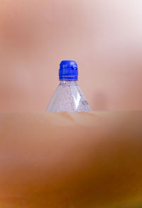 Close-up of glass bottle against blue background