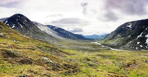 Scenic view of mountains against cloudy sky