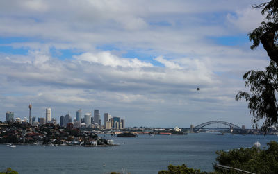 Bridge over sea and buildings against sky