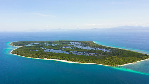 Island with a sandy beach and azure water surrounded by a coral reef. great santa cruz island.