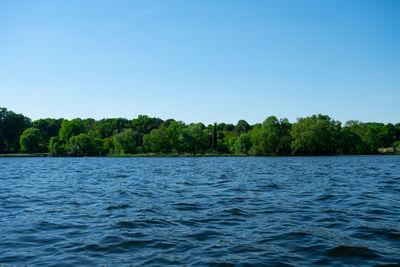 Scenic view of lake against clear blue sky