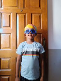 Portrait of boy wearing sunglasses while standing against wall